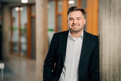 Projektleiter Planung MSR bei Projekt-HLS in Weiden im Büro. Lehnend an einer Betonsäule.